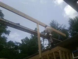 Carpenter setting a ridge beam over a new addition frame — Ice Dam Removal by Roofing Brothers in Pena Blanca