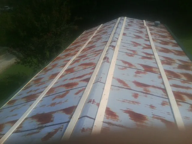 Rusted metal roof panels with new wood purlins before replacement — Storm Damage Roof Repair in Pena Blanca by Roofing Brothers