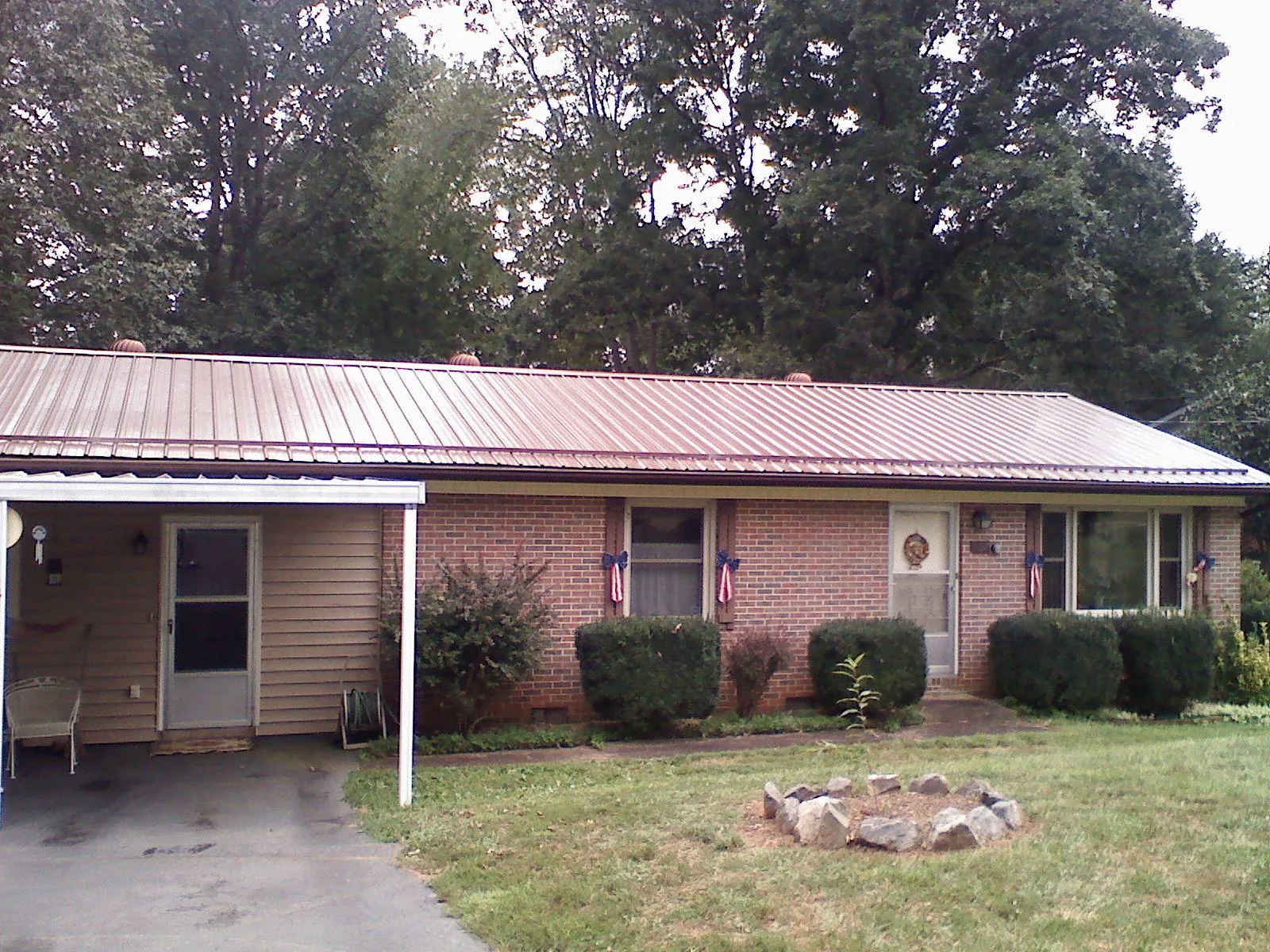 Bronze metal roof and carport on a brick ranch home — Roof Repair work by our crew in Pena Blanca